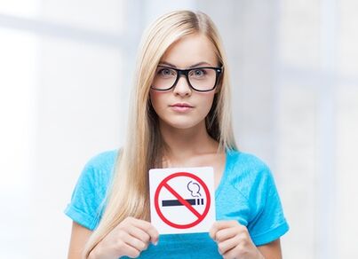 girl holding a sign prohibiting smoking at the entrance